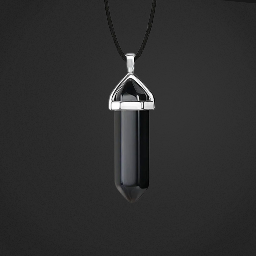 Black crystal pendant on a black cord against a dark background
