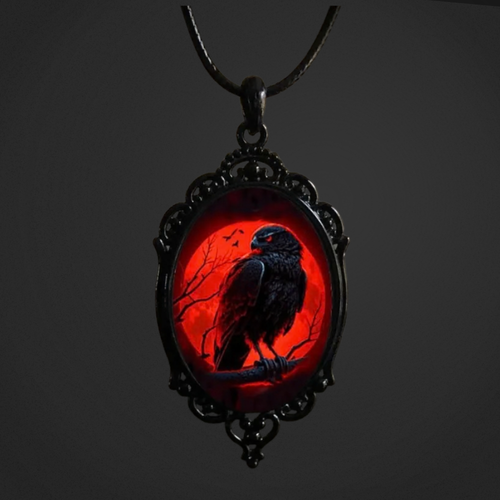 Pendant with a black bird silhouette on a red background against a dark background