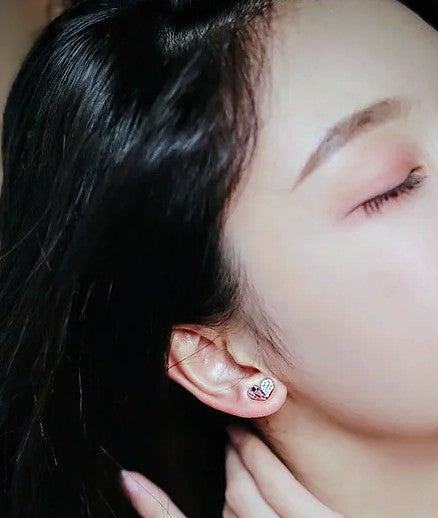 Close-up of an ear with a small earring, hair partially covering the face.