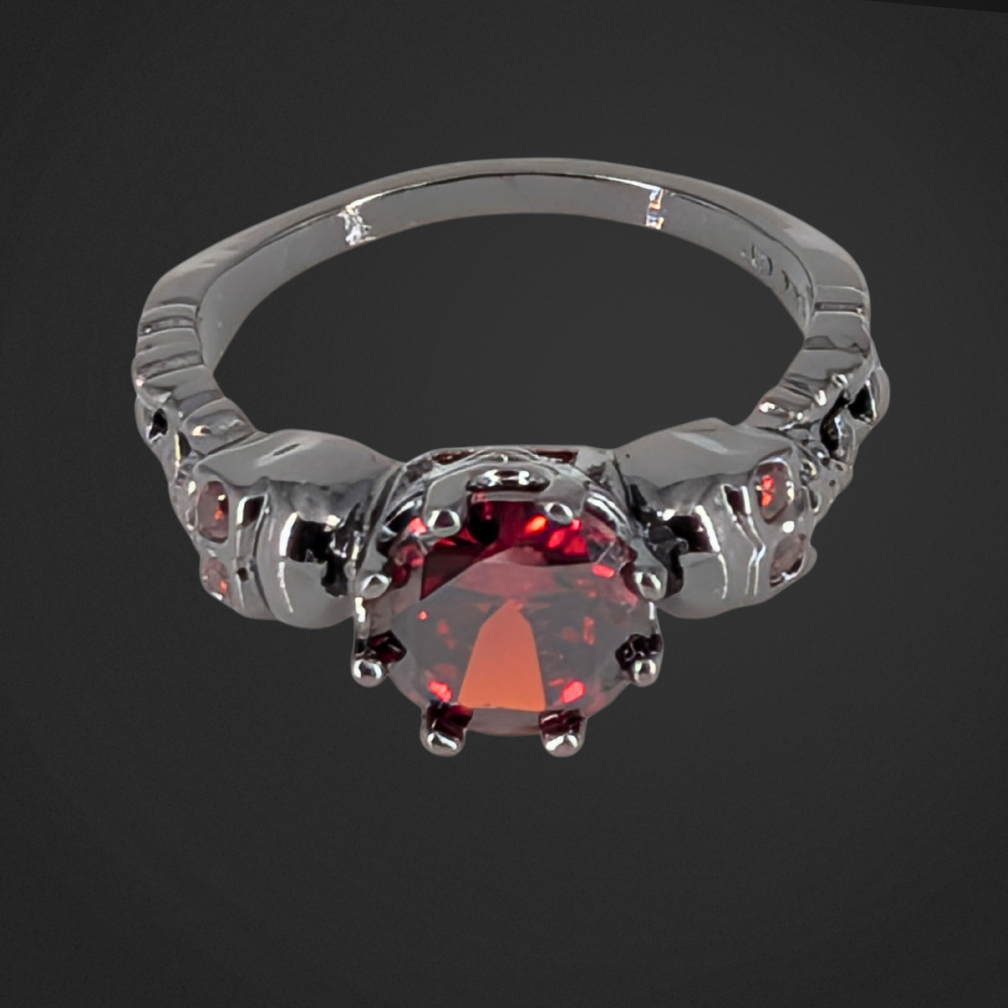 Gothic ring with a red gemstone on a black background