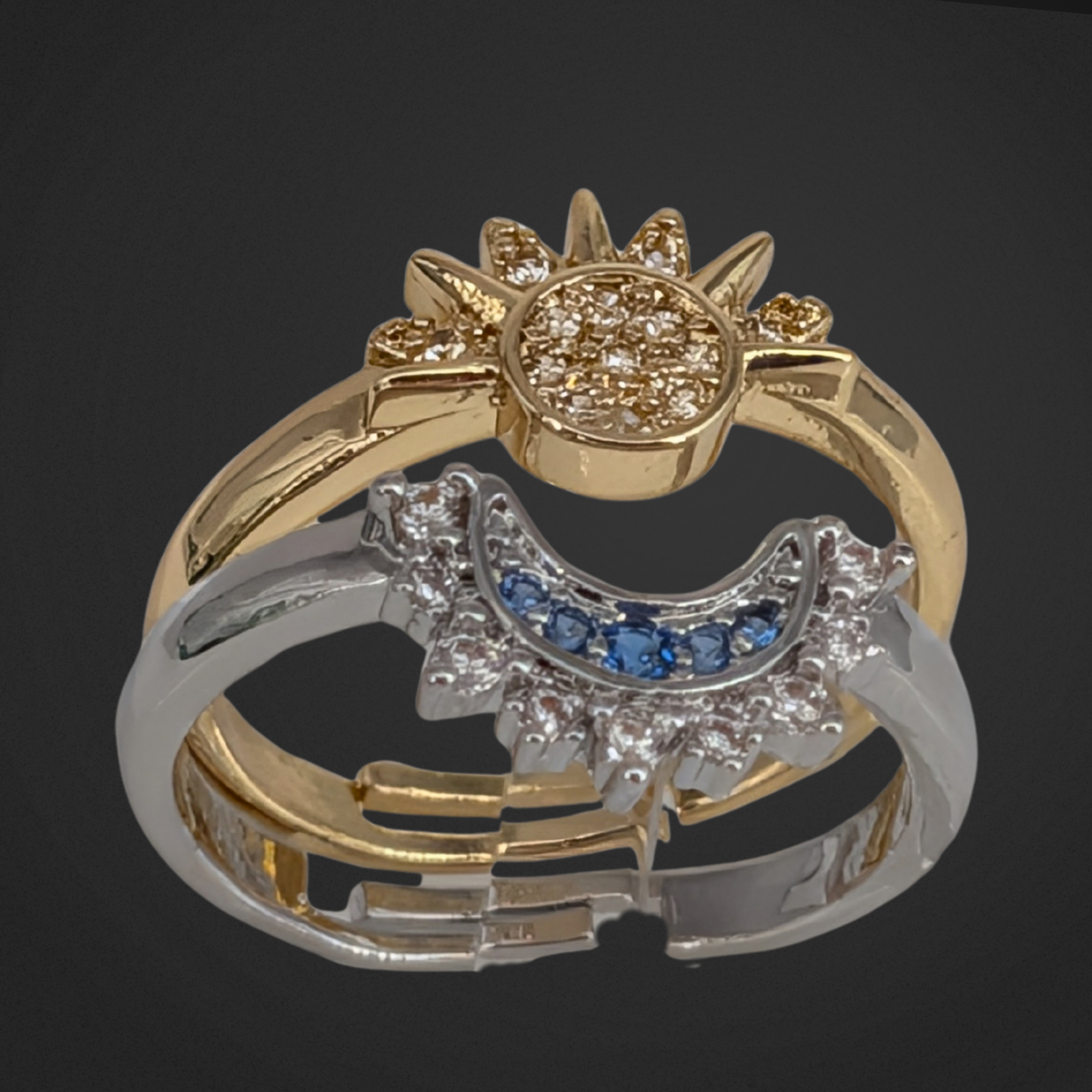 Two gold and silver rings with gemstones on a black background