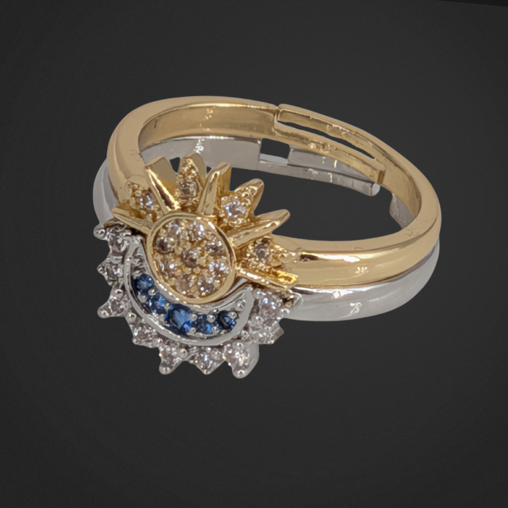 Image of two rings sitting on one another. one is half a moon, other is half a sun. The moon is silver and the sun is gold. Both have small gems.