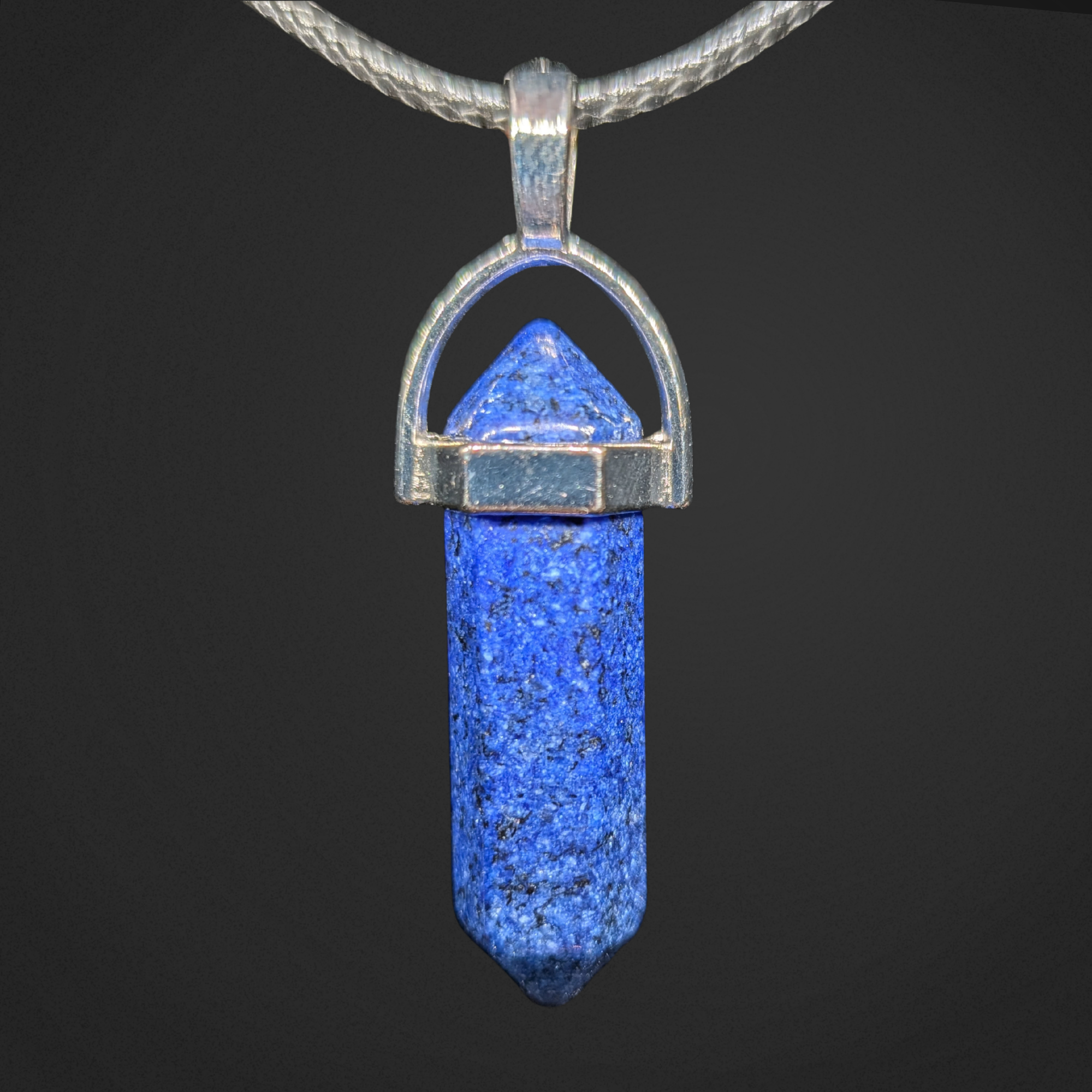 Blue pendant with silver setting on a black background