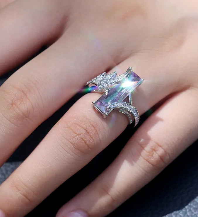 Sparkling gemstone ring on a finger with a blurred background