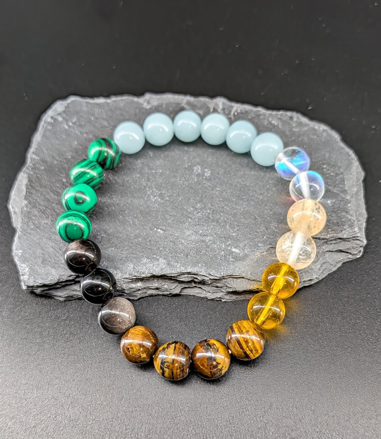 Multicolored beaded bracelet on a gray stone surface