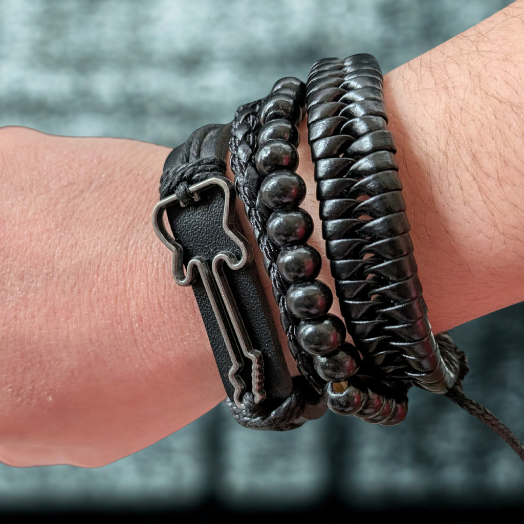Close-up of a wrist wearing two black leather bracelets with metal accents.