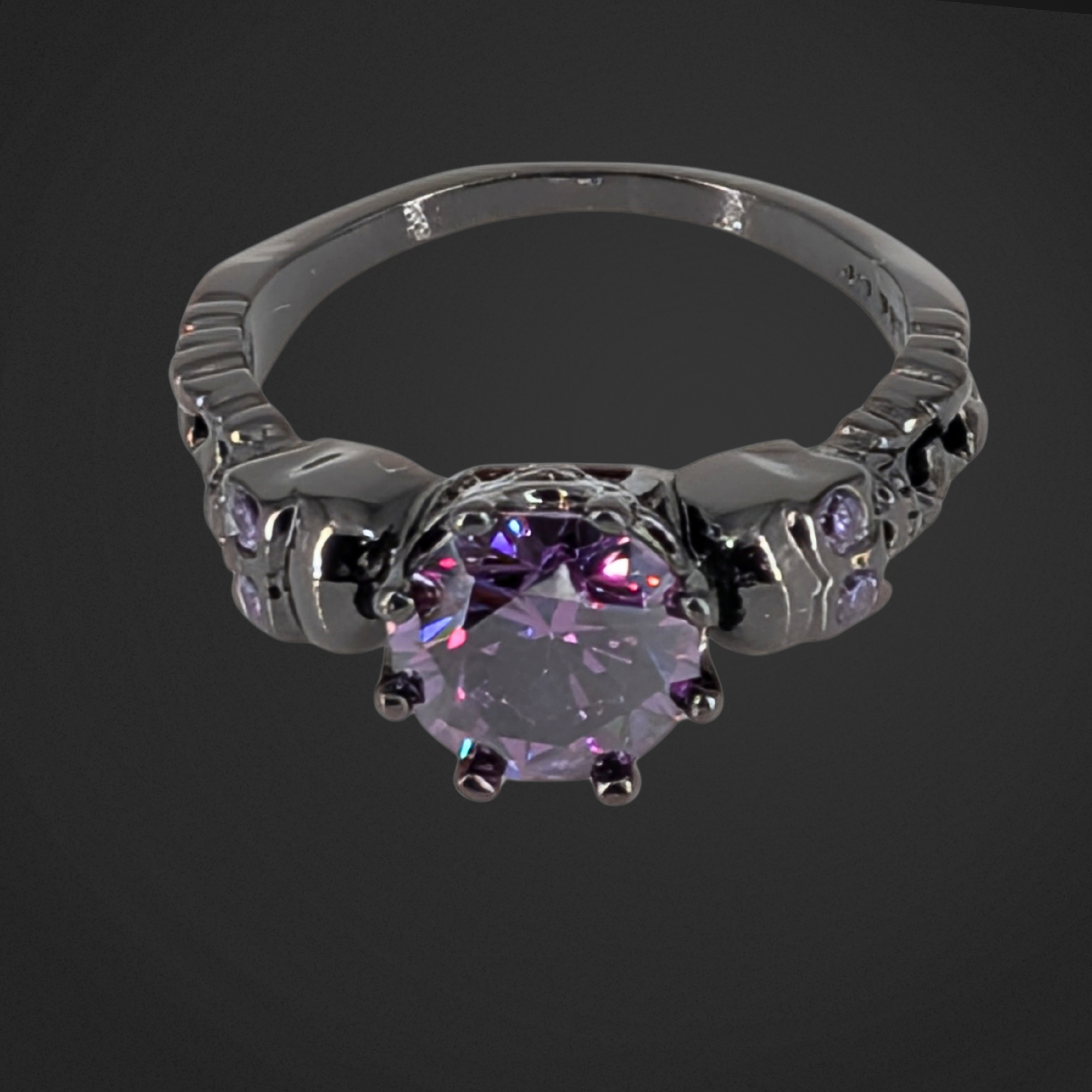 Black ring with a purple gemstone on a black background