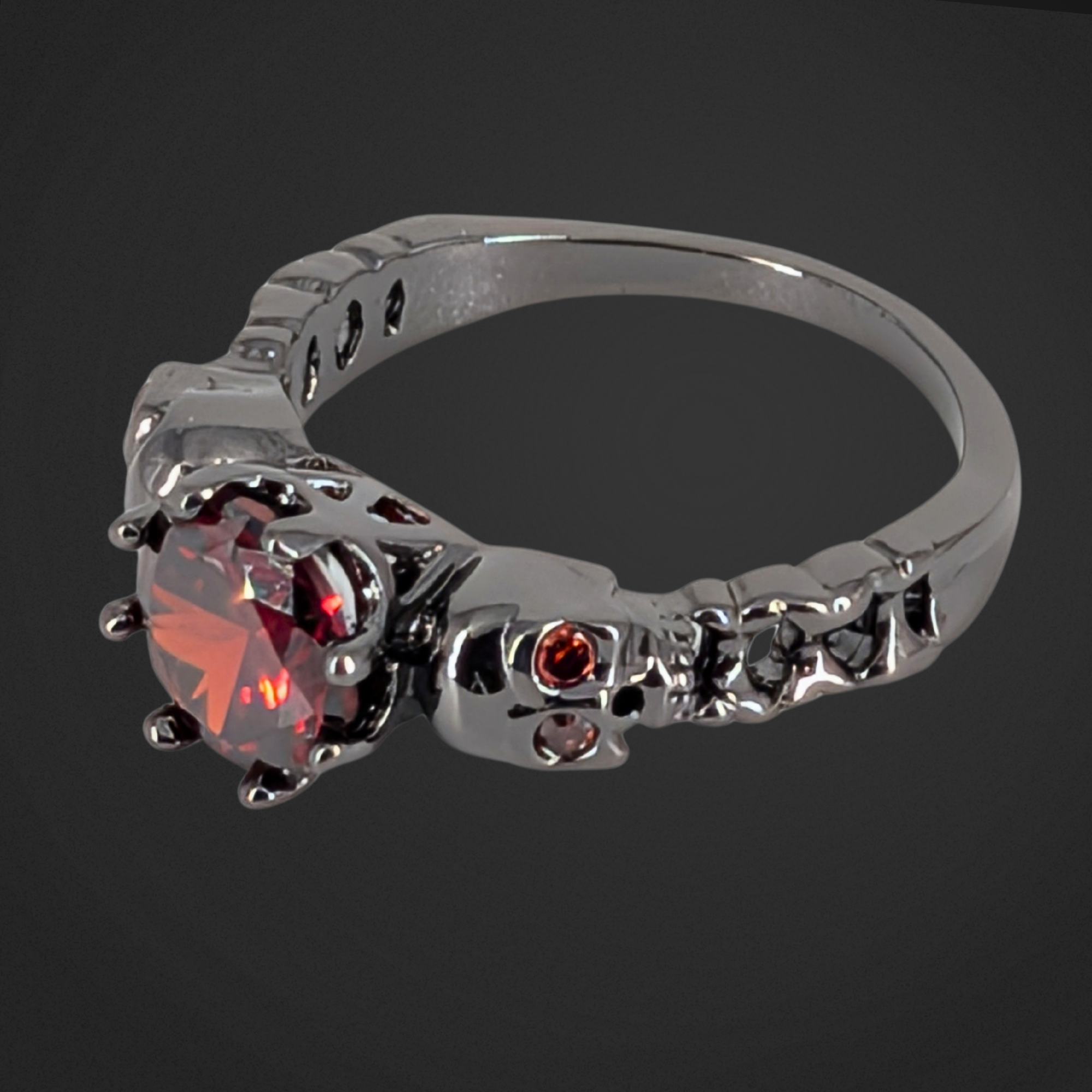 Black ring with red gemstone on a black background