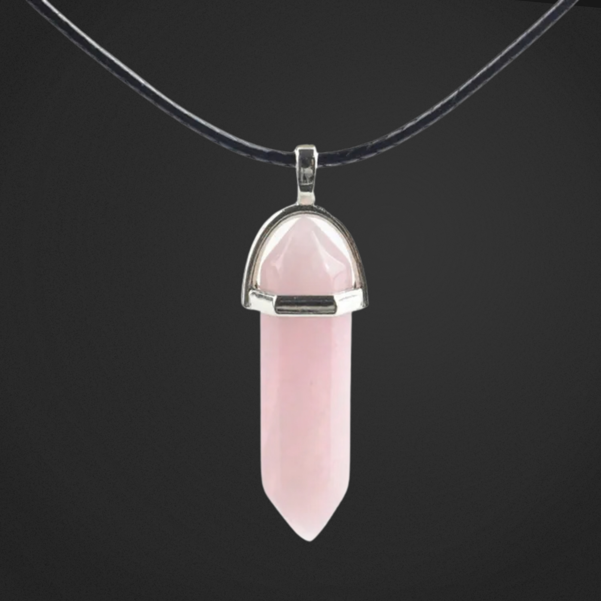 Pink crystal pendant on a black cord against a black background