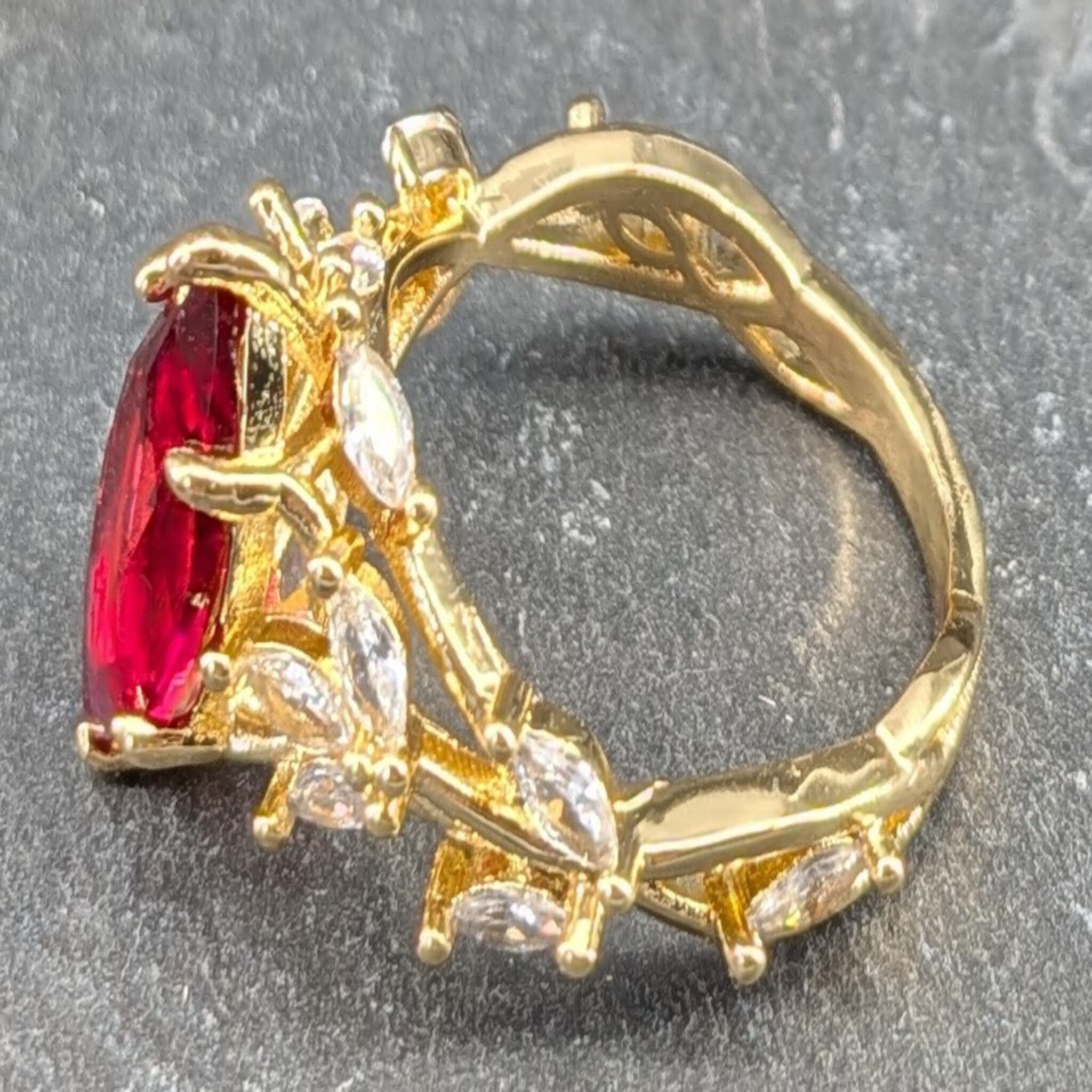 Gold RING with a red gemstone on a gray background
