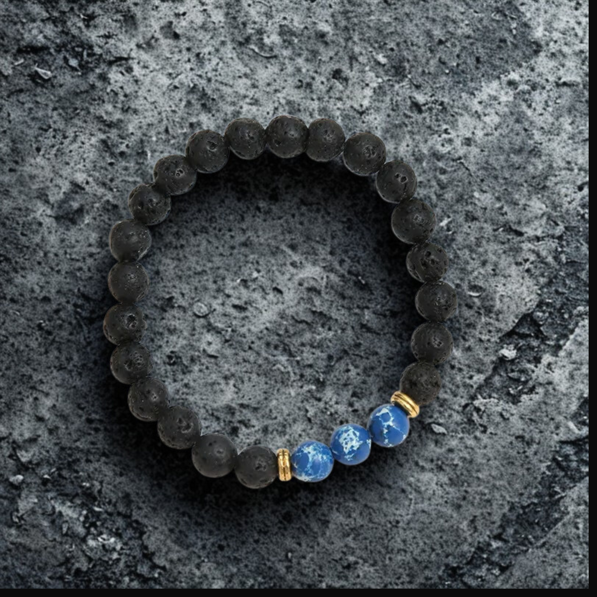 Bracelet with blue and gold beads on a textured gray surface