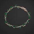 Silver bracelet with green gemstones on a black background