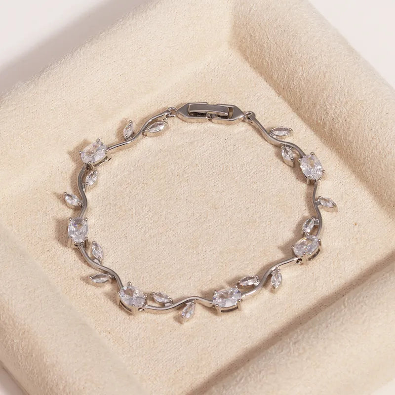 Silver bracelet with floral design on a beige cushion