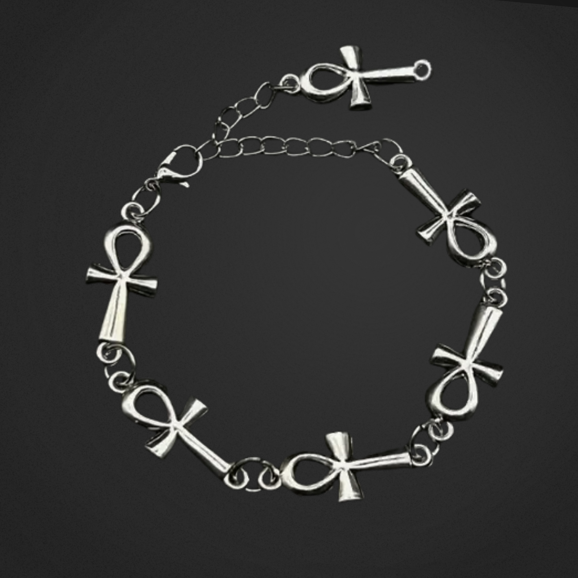 Silver bracelet with cross designs on a black background