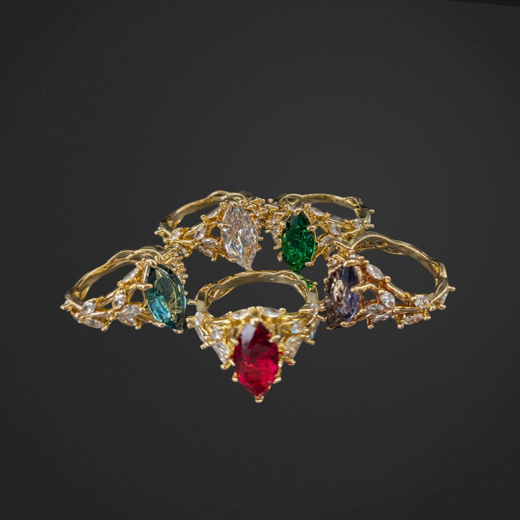 Gold jewelry set with colorful gemstones on a black background