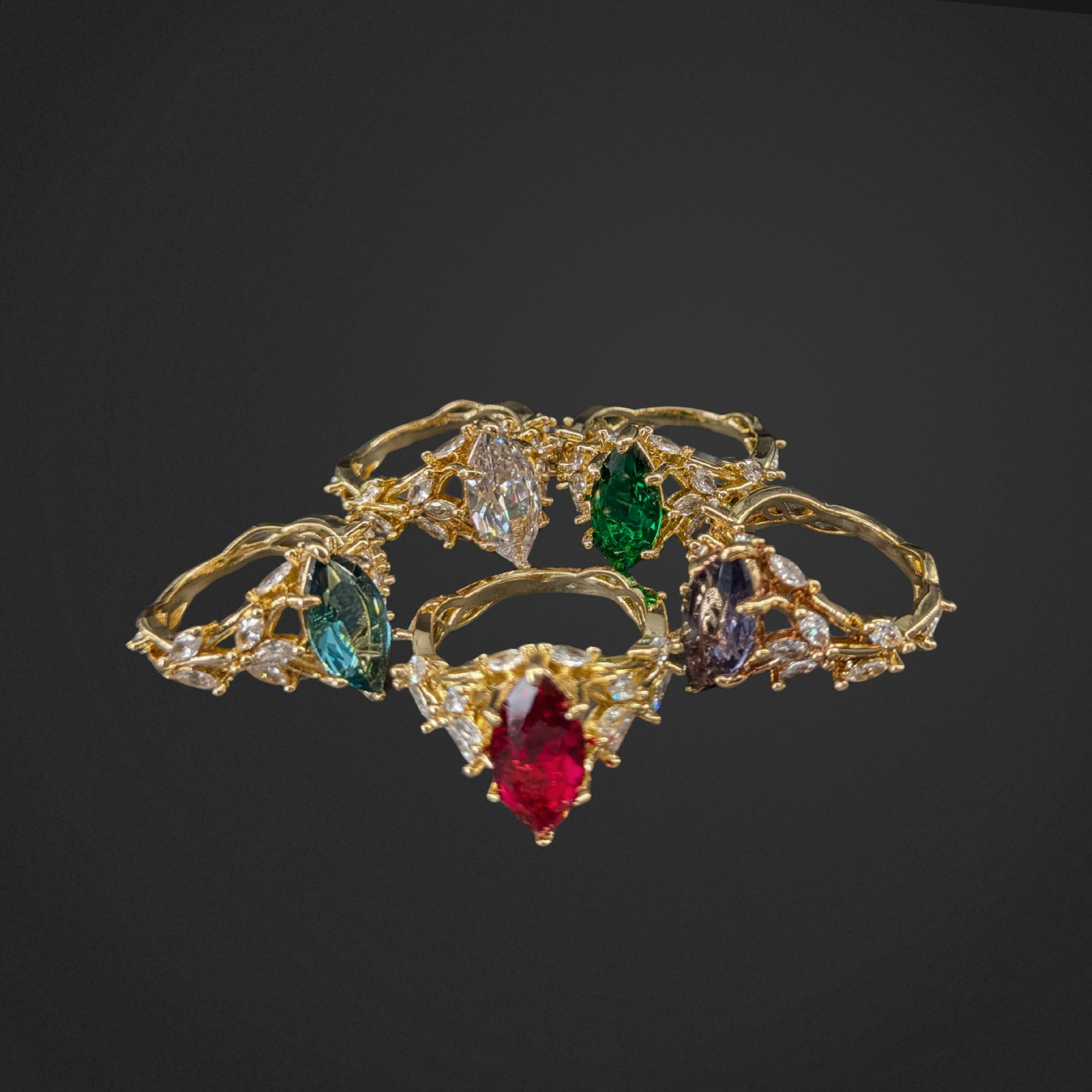 Gold jewelry set with colorful gemstones on a black background