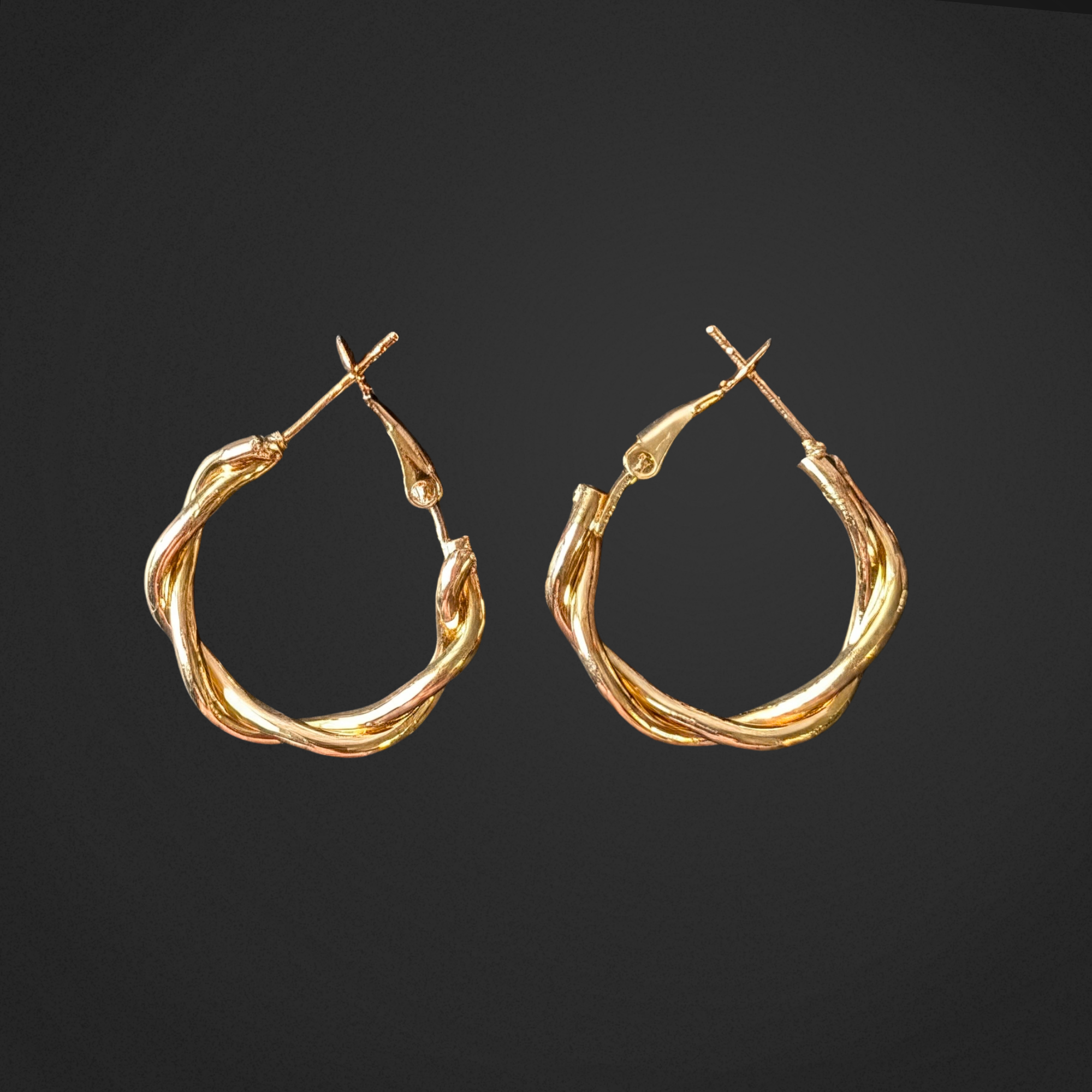 Pair of gold hoop earrings on a black background