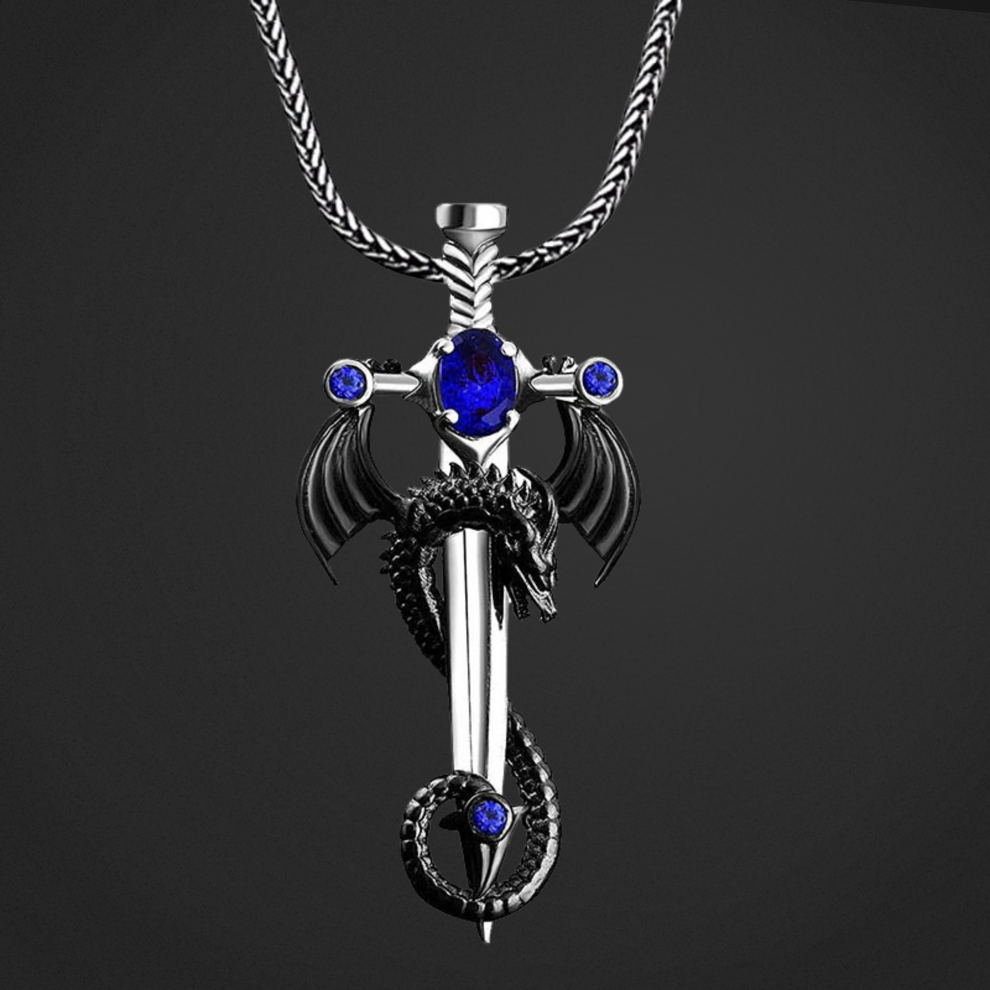 Silver sword pendant with blue gemstones on a black background