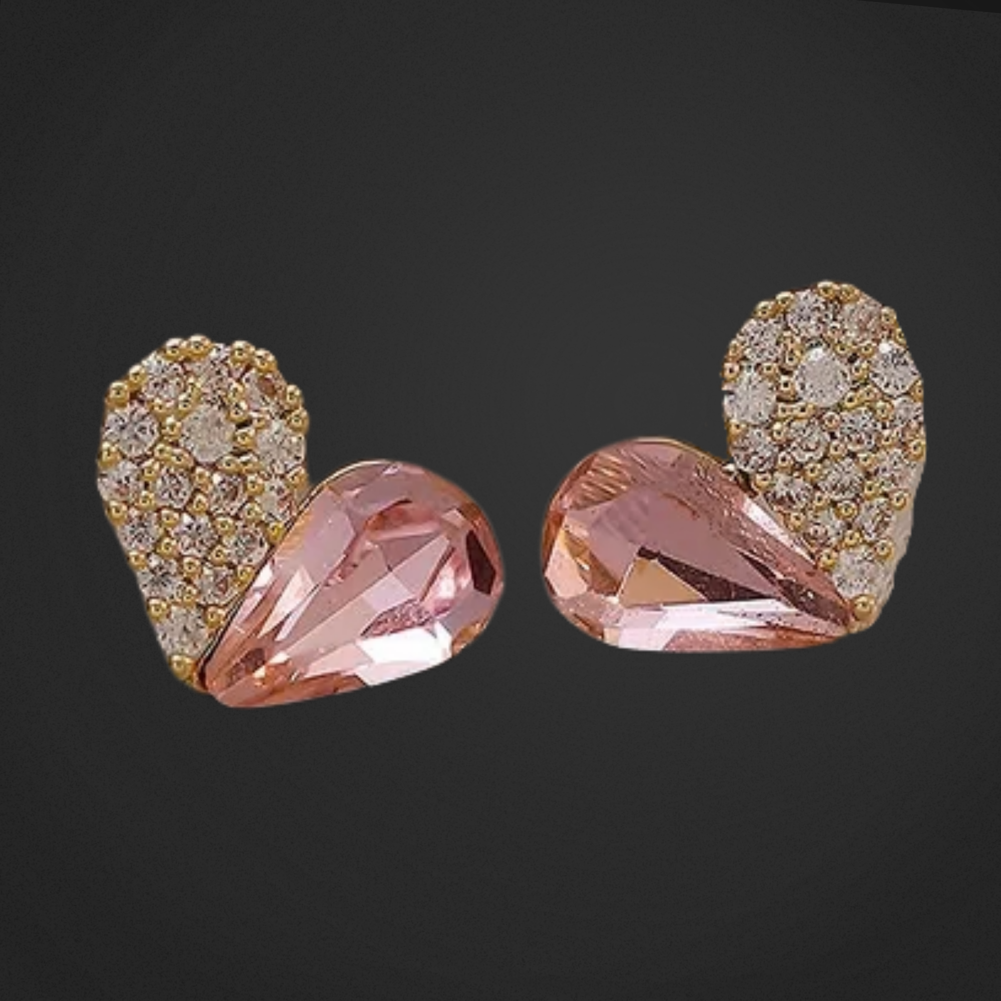 Pair of earrings with pink teardrop stones and gold and diamond accents on a black background