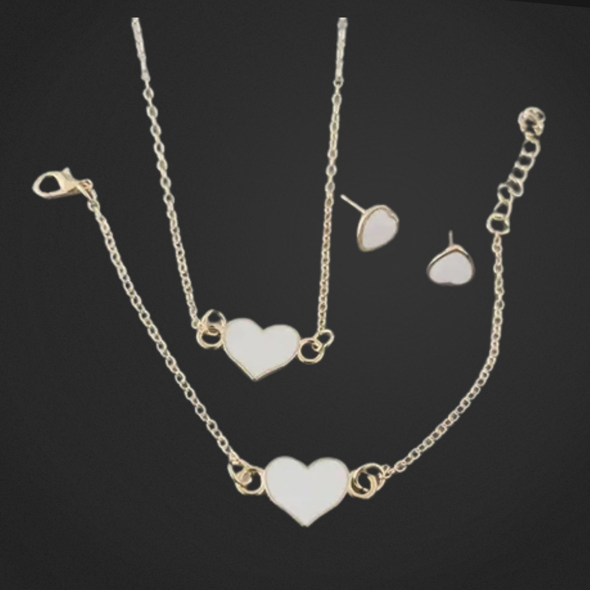 Jewelry set with heart-shaped pendants on a black background