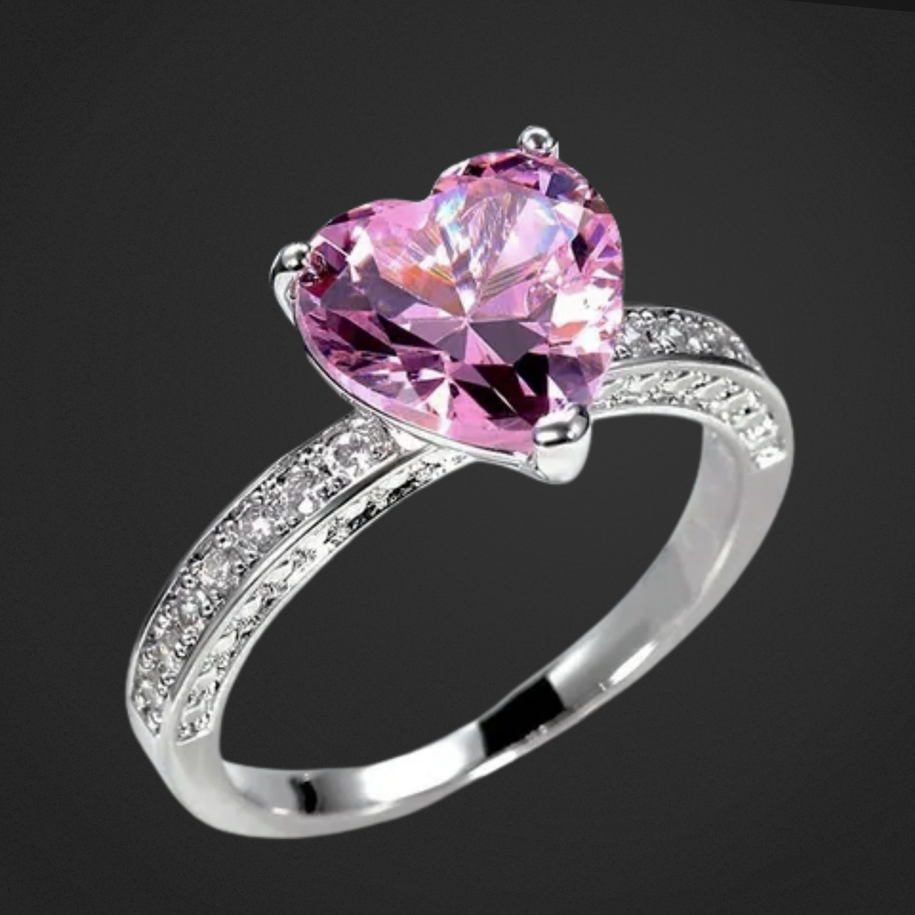 Silver ring with a pink heart-shaped gemstone on a black background