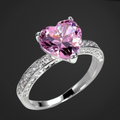 Silver ring with a pink heart-shaped gemstone on a black background