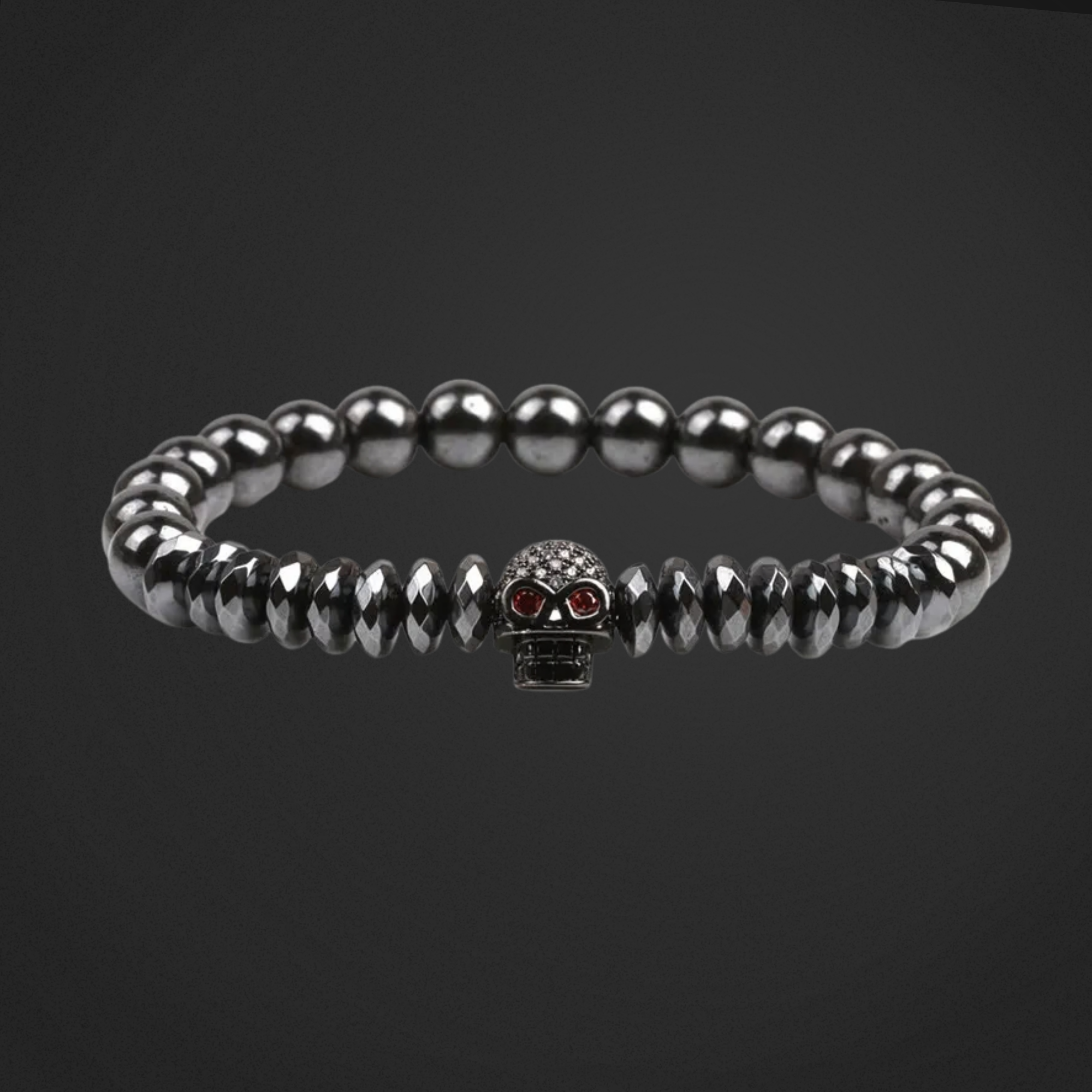 Silver beaded bracelet with a skull charm on a black background