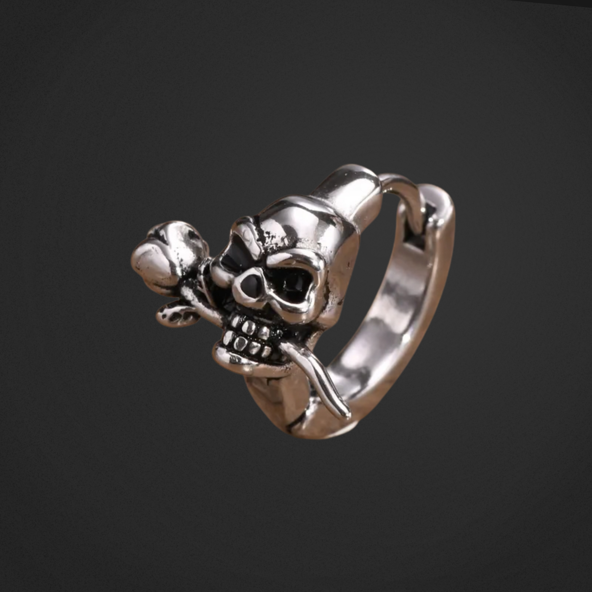 Silver skull earring on a black background