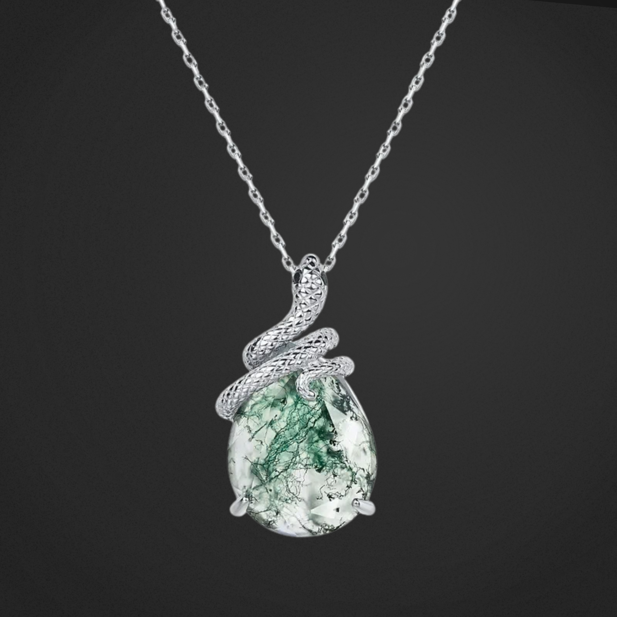 Silver necklace with a green teardrop pendant on a black background