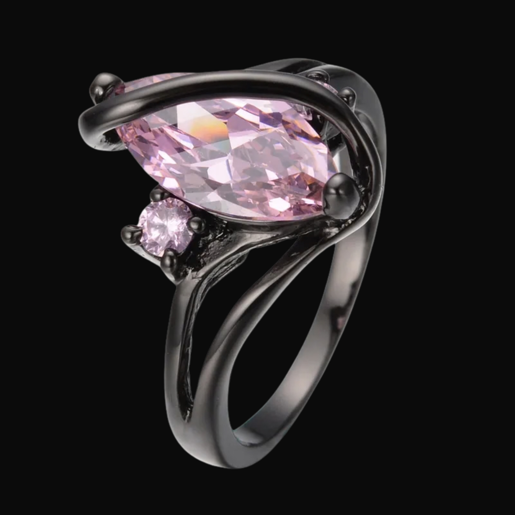 Ring with pink gemstone and black metal setting on a black background